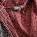 Close-up of a textured pink robe with a brand label.