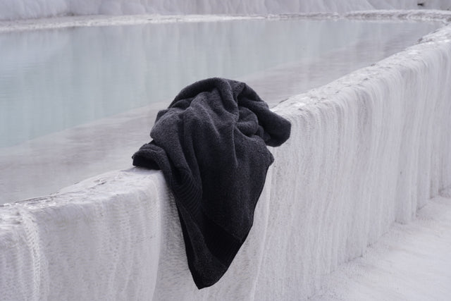 Black towel draped over a textured white surface