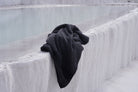 Black towel draped over a textured white surface