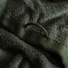 Close-up of dark green textured towel with a knitted pattern