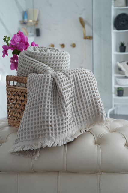 Minoa USA Canada Seren organic cotton waffle luxury bath towels rolled up in a basket showcasing sustainable luxury