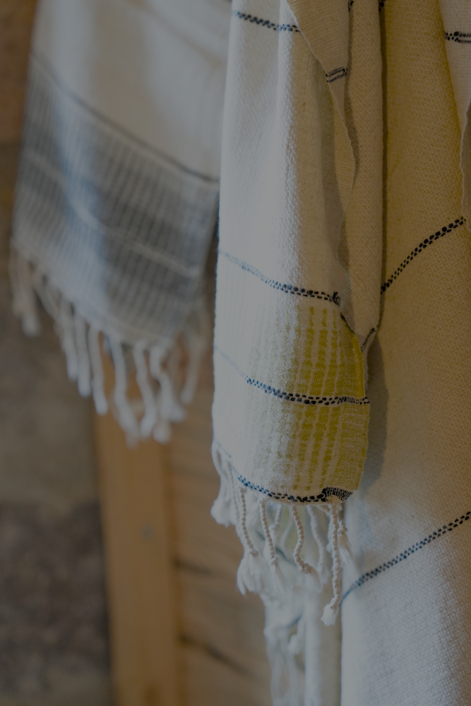 Towel with striped pattern and fringes on a wooden surface