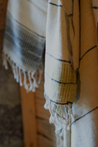 Towel with striped pattern and fringes on a wooden surface
