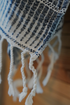 Close-up of a textured towel with fringes on a blurred background