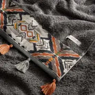 Textured towel with geometric pattern and tassels