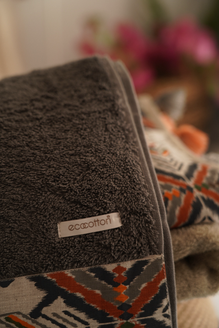 Brown towel with 'ecootton' label on a blurred background