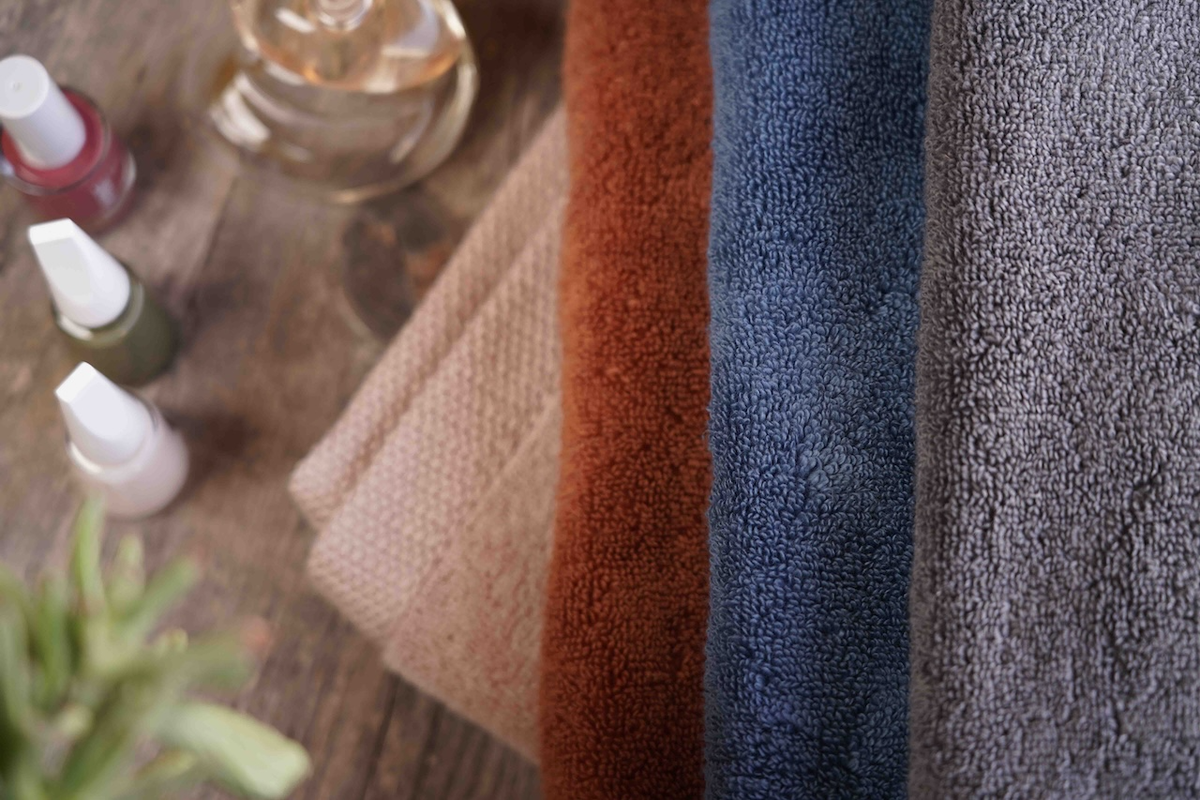 Close-up of textured towels in various colors on a wooden surface.