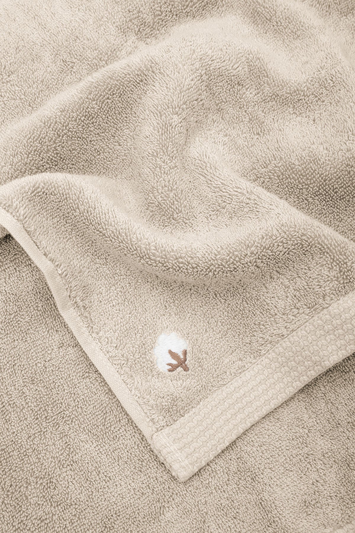 Close-up of Jasper 600-gram organic Aegean cotton luxury bath, hand, and washcloth towels in Vanilla Embrace, showcasing soft plush texture, warm tone, and luxurious fabric