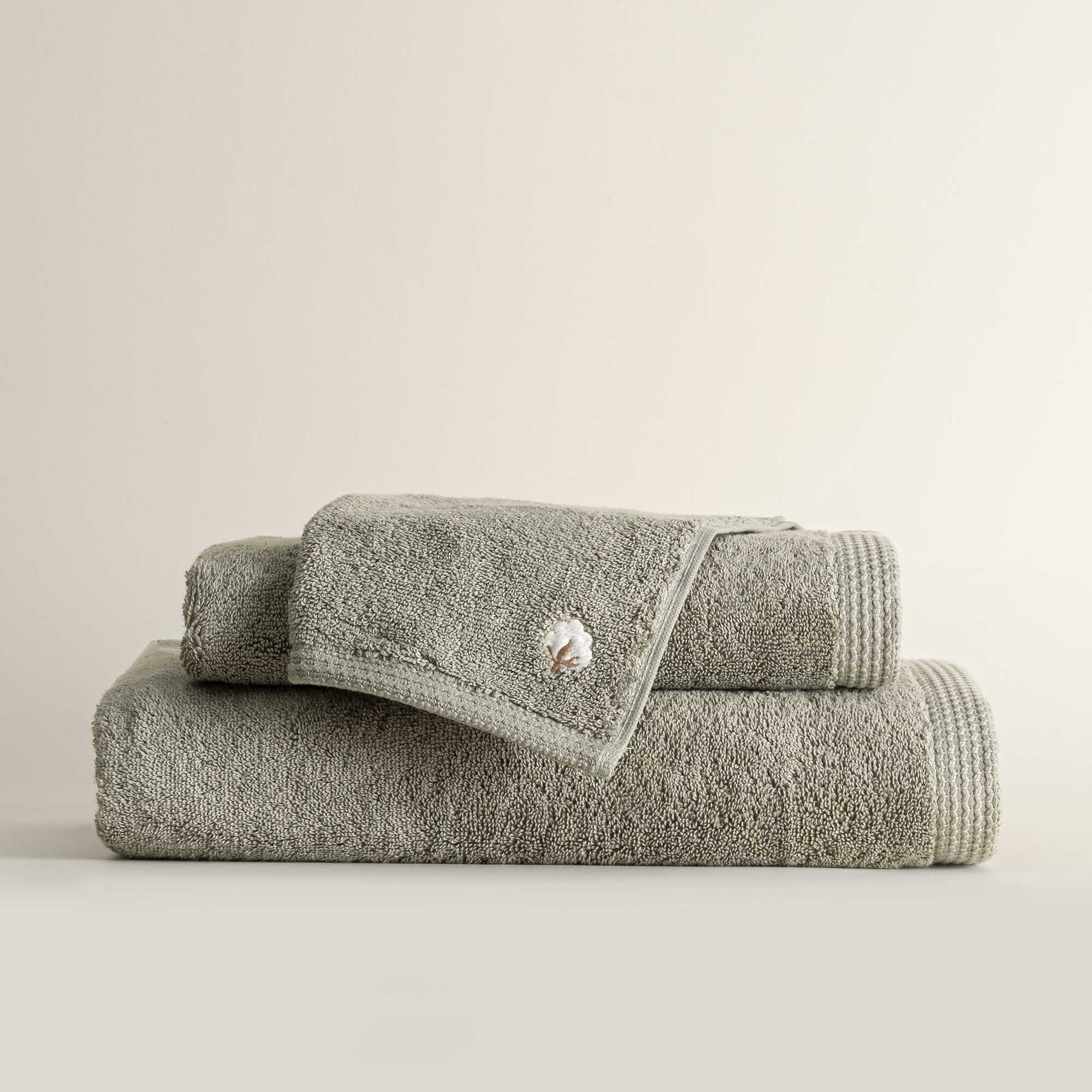 Three folded Jasper 600-gram organic Aegean cotton luxury bath, hand, and washcloth towels in Mossy Muse, showcasing soft plush texture, earthy tone, and luxurious fabric