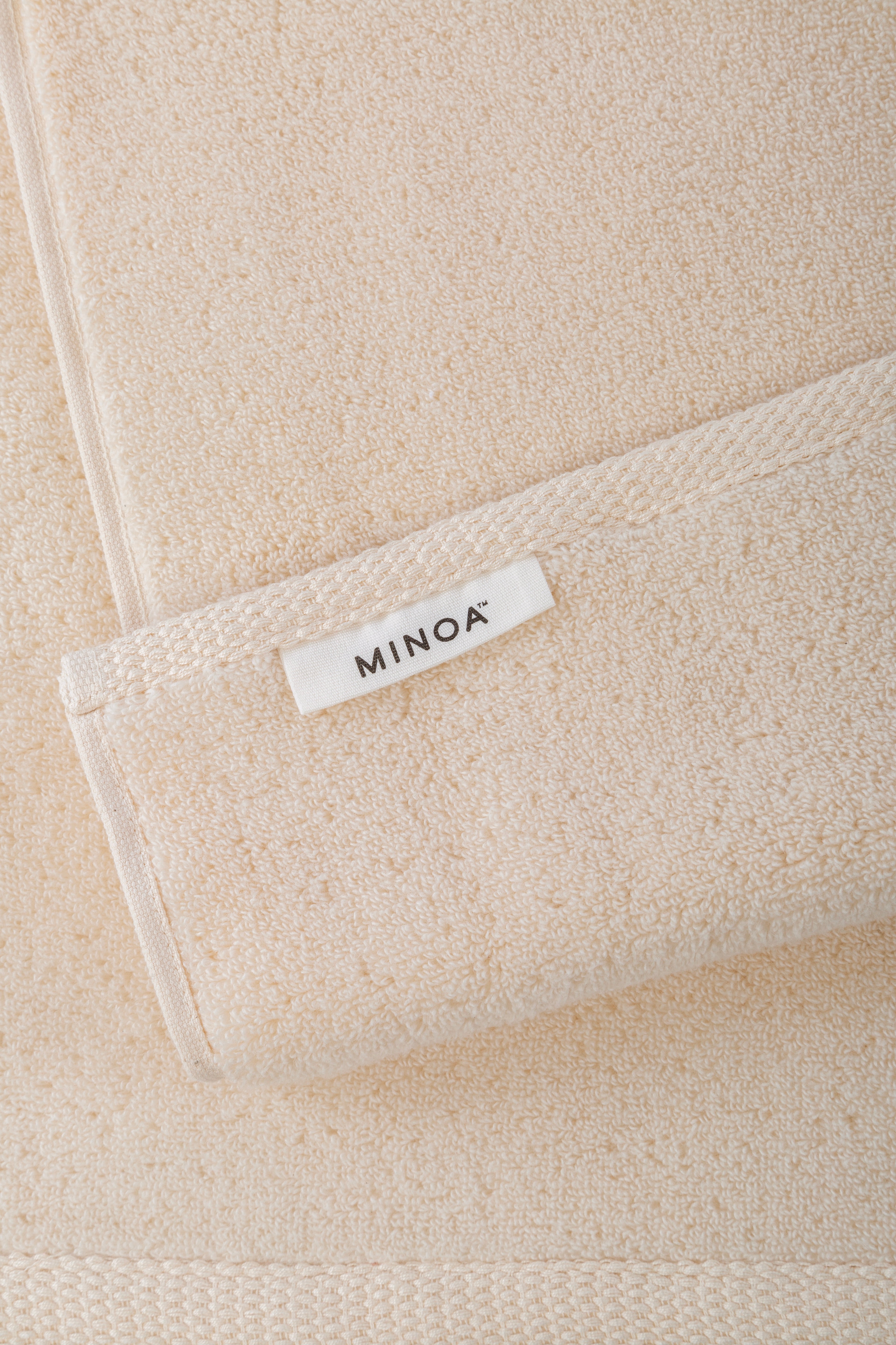 Close-up of a beige towels with a 'MINOA' label.