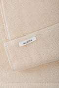 Close-up of a beige towels with a 'MINOA' label.