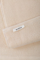 Close-up of a beige towels with a 'MINOA' label.