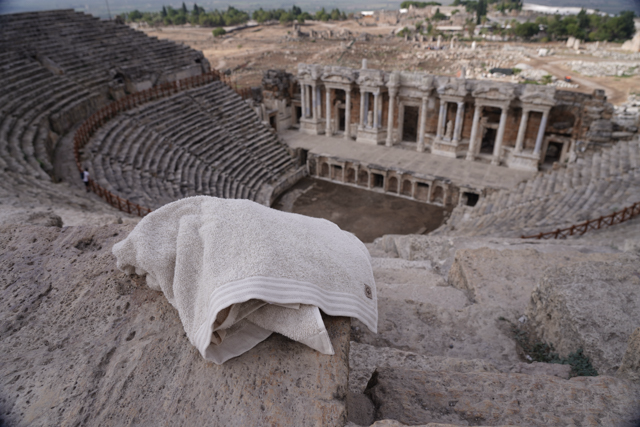 Towel draped over a stone in an ancient amphitheater with ruins in the background