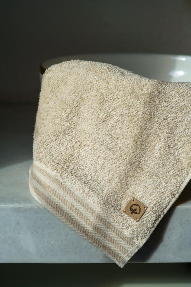 Beige towel with a brand logo on a metallic surface