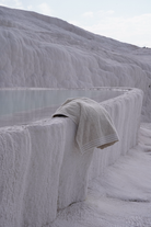 Towel draped over a stone ledge in a white, textured landscape