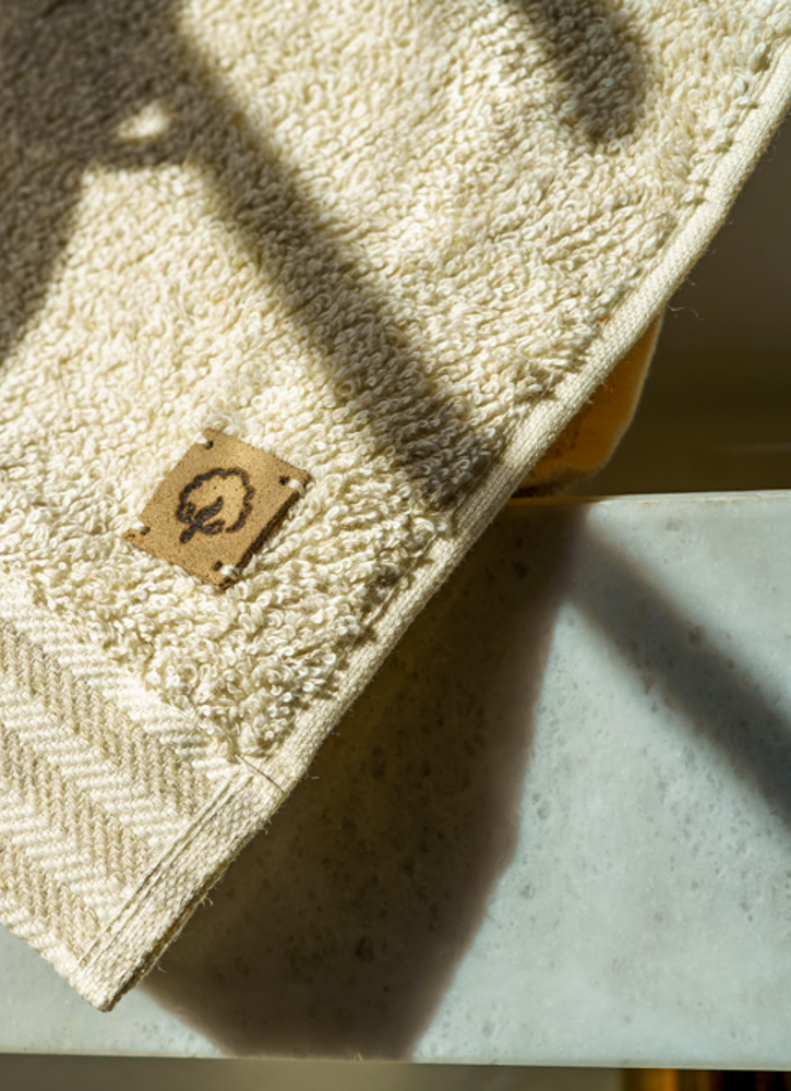Beige towel with a logo on a light surface