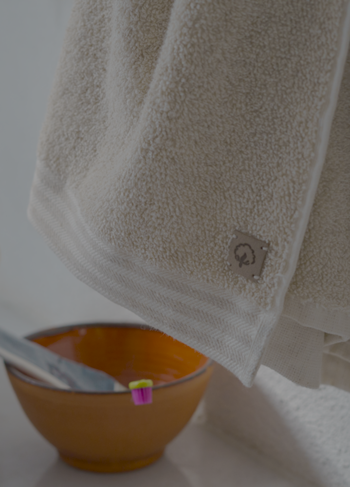 Brown towel with a logo hanging on a white surface