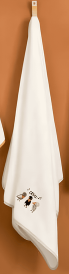 White towel with crow characters hanging on a wooden hook against a brown background