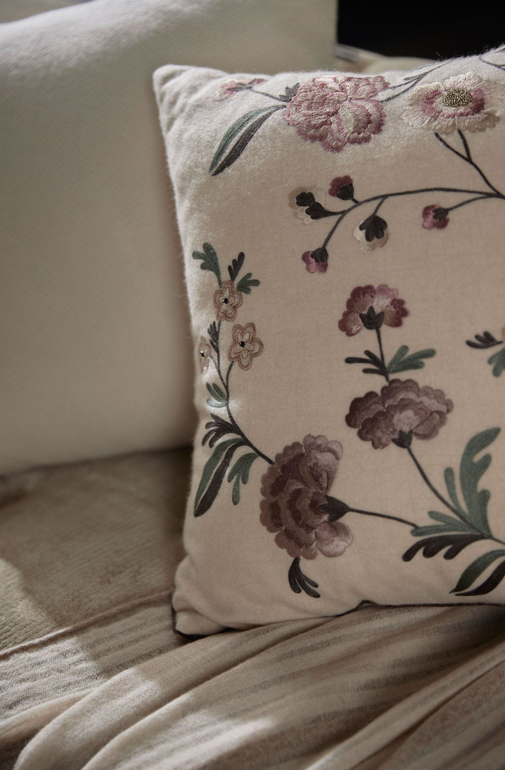 Luxury cushion featuring an elegant floral pattern, showcasing rich texture and design.