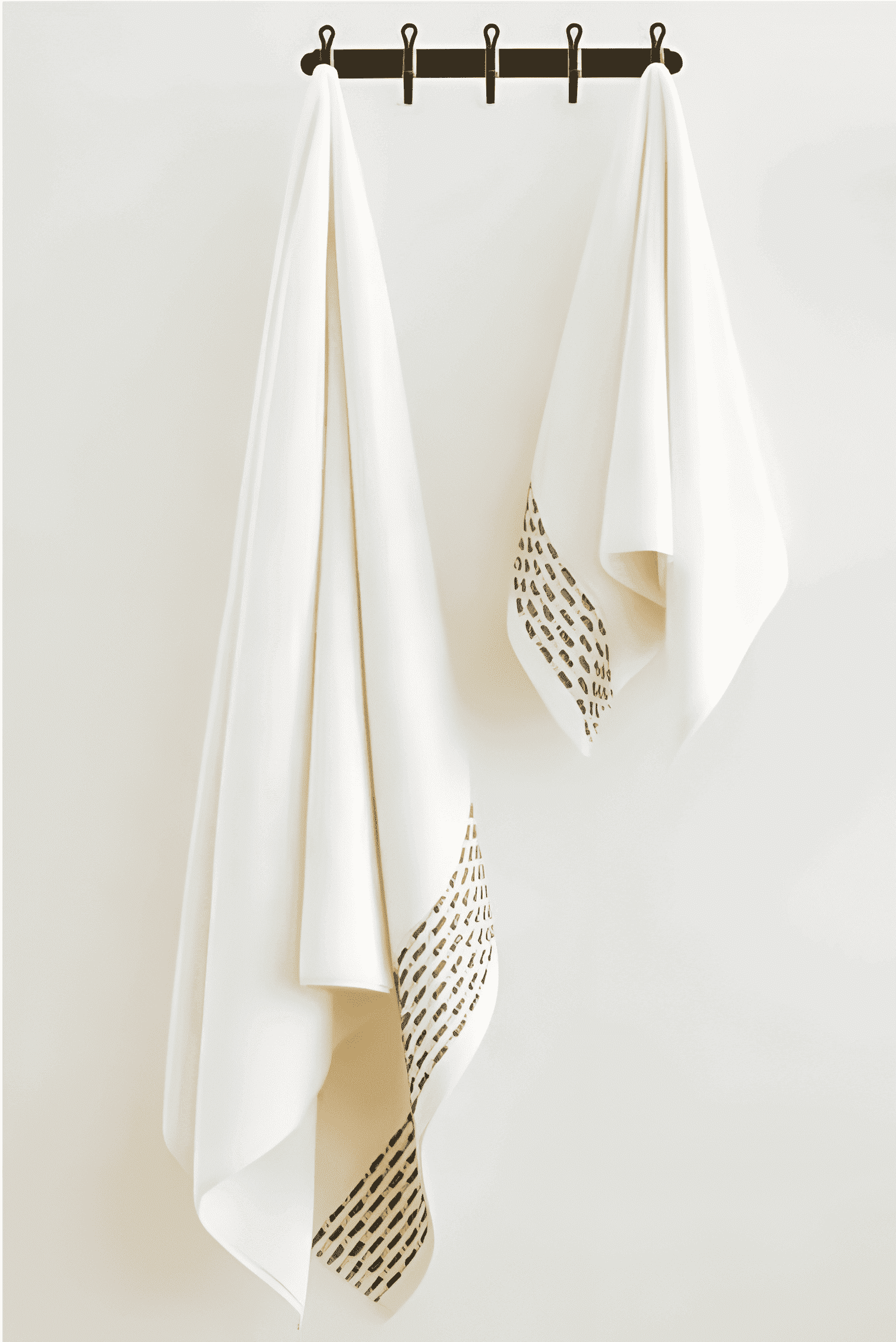 Two Calm 550-GSM Cotton Towels in ivory and green, organic cotton towels hanging on a towel hanger, showcasing their soft texture and soothing color combination.