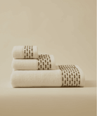 Calm 550-GSM Cotton Towel in ivory and green, an organic cotton towel providing a plush, absorbent texture with a fresh and soothing color combination.