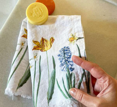 Hand-drawn floral towel with a hand holding it, featuring yellow tulips and blue hyacinths.