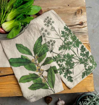 Two fabric towels with botanical designs on a wooden surface.