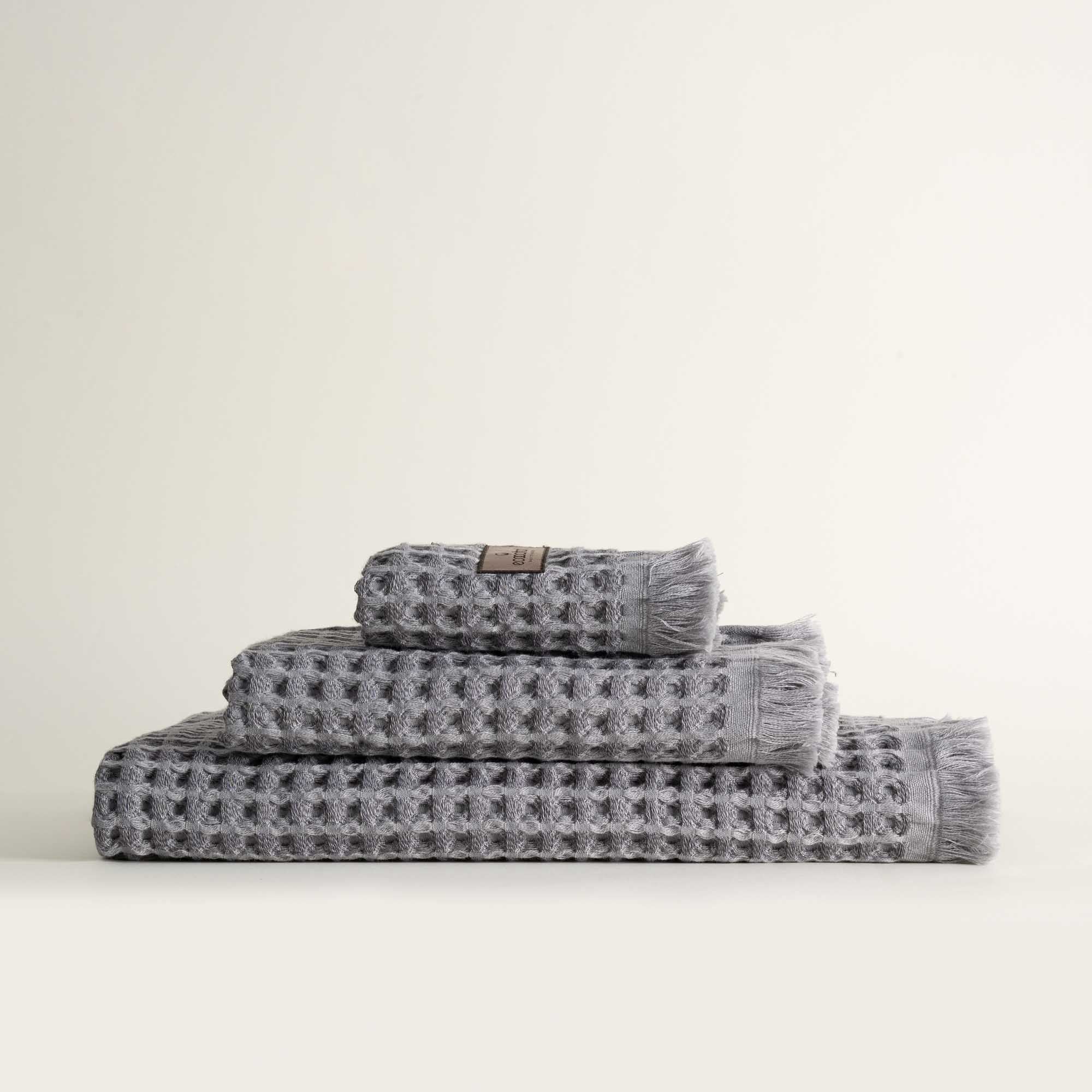 Three-piece Silver Delight Seren Organic Cotton Waffle Bath Set, including bath towel, hand towel, and washcloth, gently arranged to highlight its soft texture and natural, eco-friendly design.