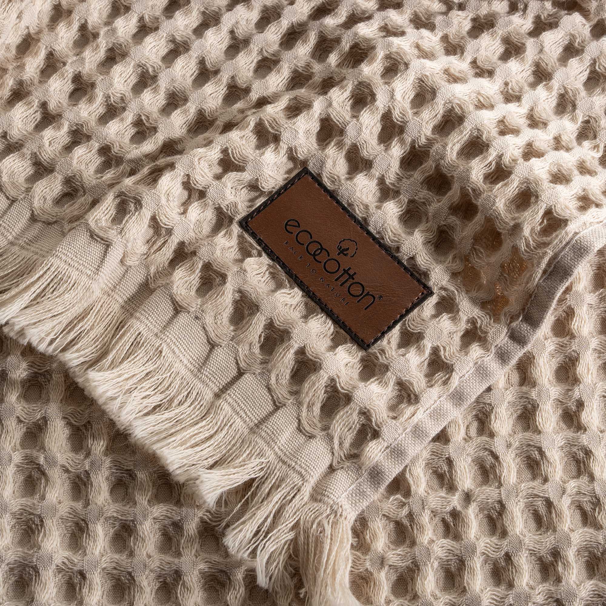 Close-up of Ecocotton tag on Yummy Vanilla Seren organic cotton waffle luxury bath towel, highlighting sustainable luxury and soft texture