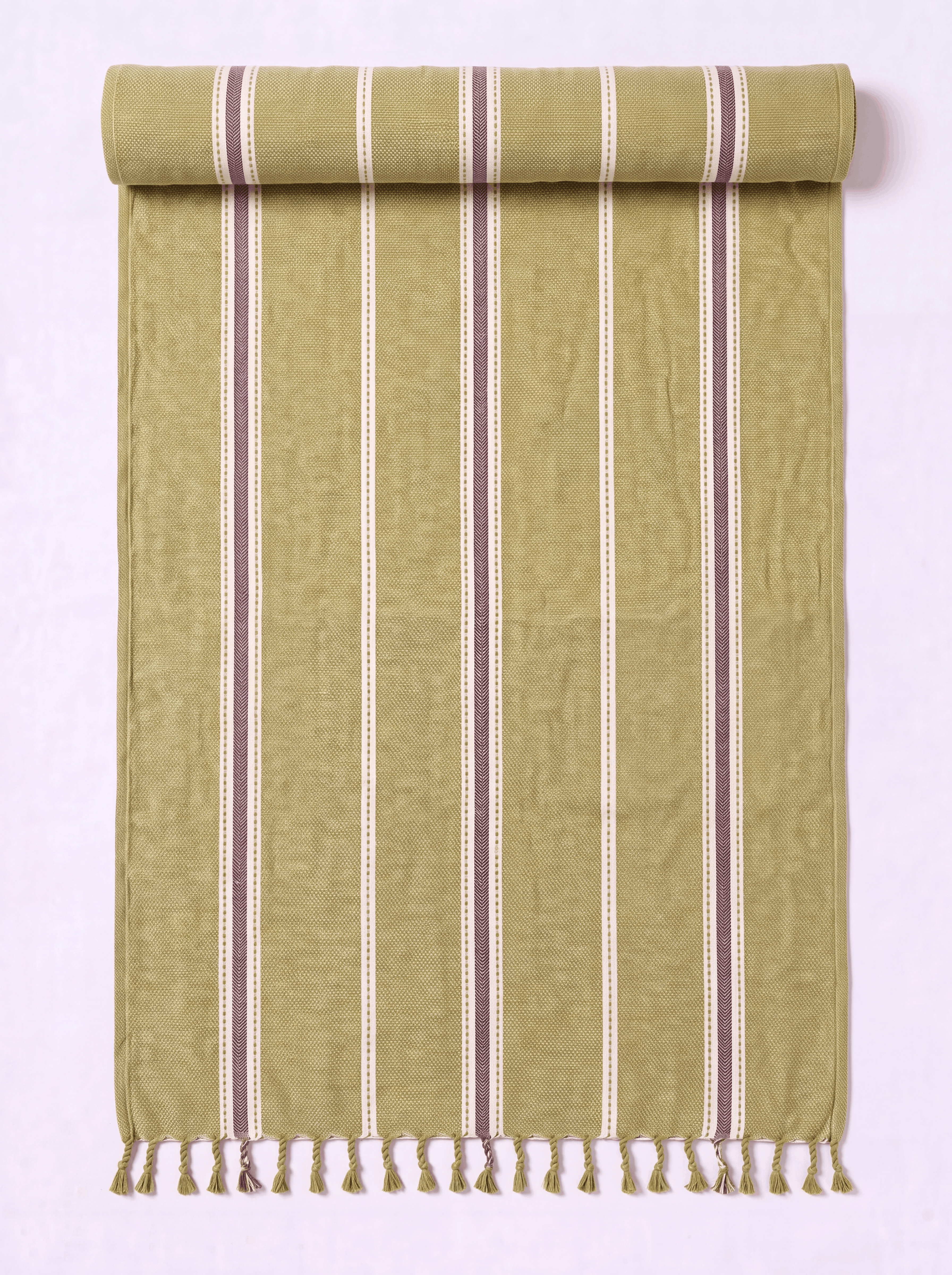 A rolled-out woven towel in a muted olive green color with vertical stripes in cream and dark brown, finished with a fringed tassel edge.