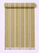 A rolled-out woven towel in a muted olive green color with vertical stripes in cream and dark brown, finished with a fringed tassel edge.