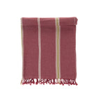 Folded red towel with white and yellow stripes on a white background