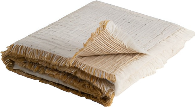 Folded textured blanket with frayed edges on a white background