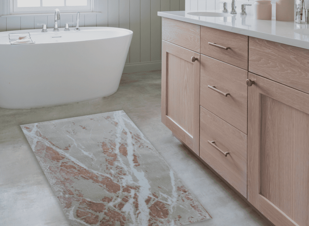 Bathroom with wooden vanity, freestanding bathtub, and patterned rug.