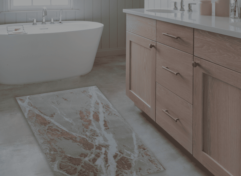 Bathroom with wooden vanity, freestanding bathtub, and patterned rug.