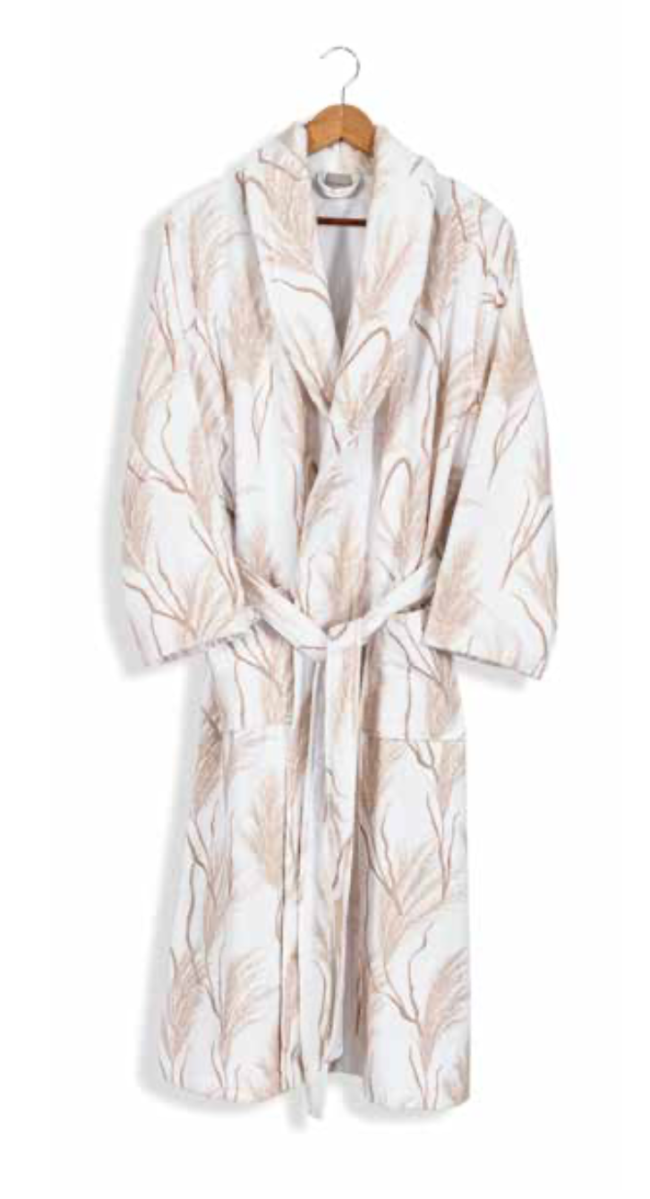 White bathrobe with soft beige leaf pattern hanging on wooden hanger — serene sustainable home textile with nature-inspired design.