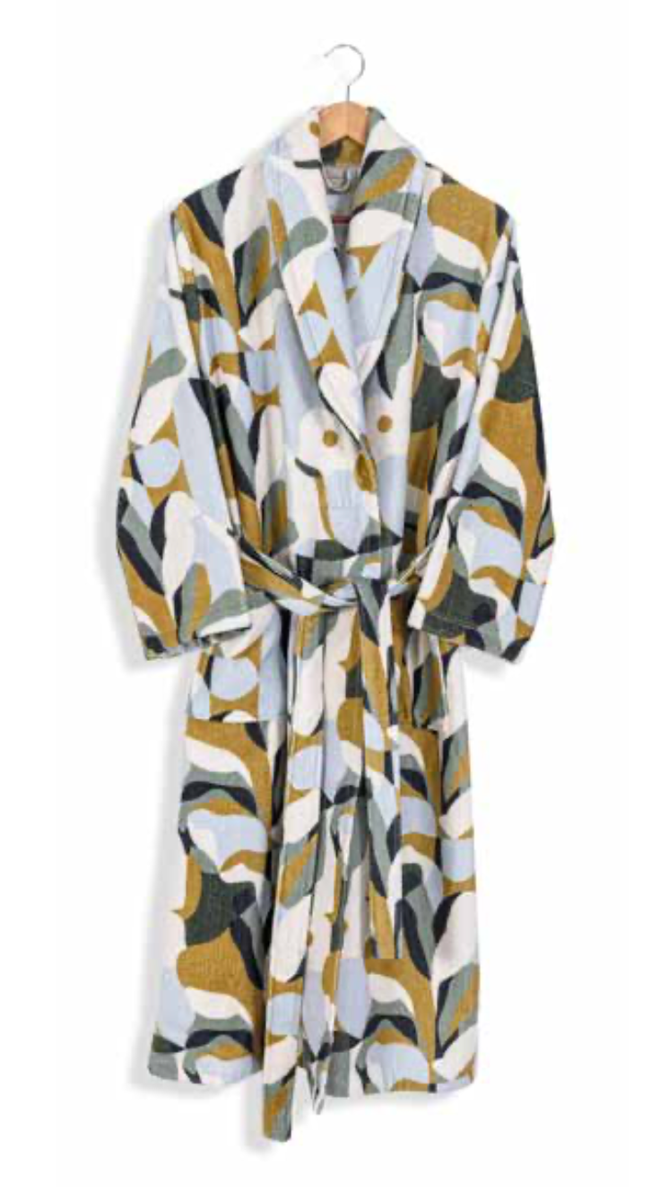 White bathrobe with abstract earth-toned pattern in olive, mustard, and soft blue — bold modern sustainable textile design.