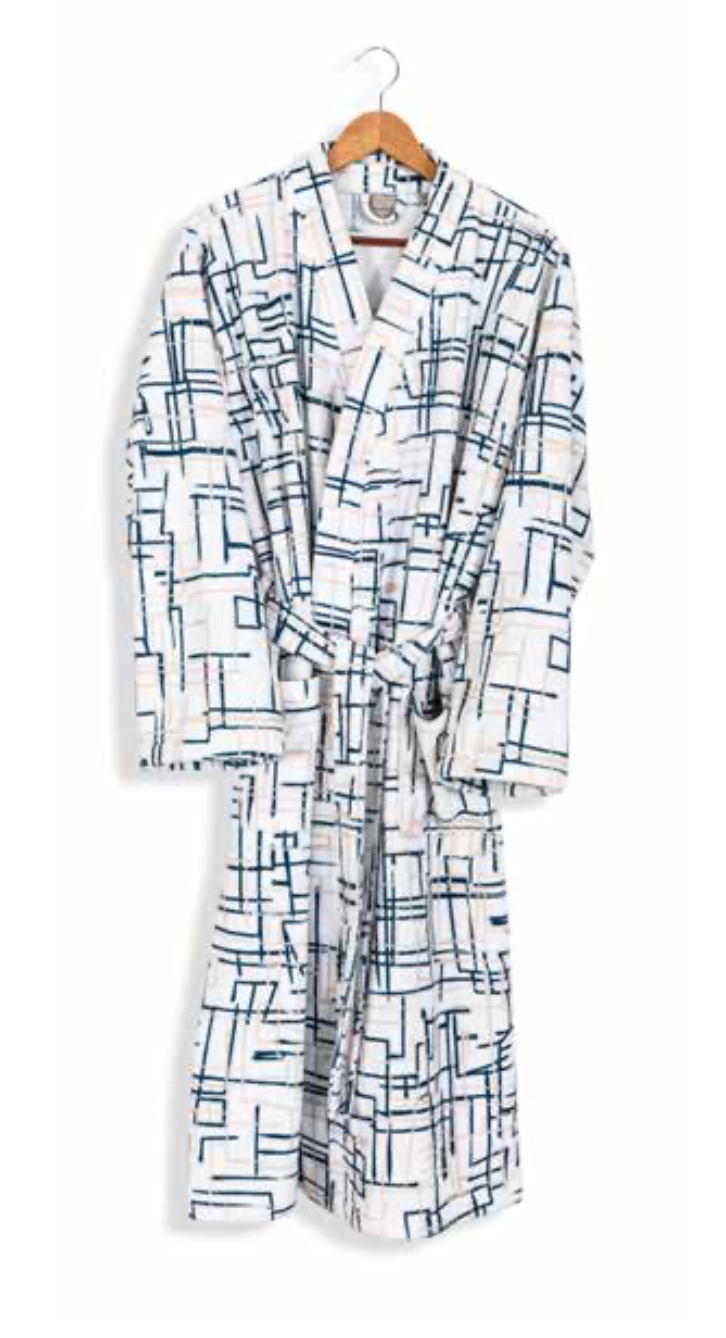 White bathrobe with modern navy geometric line pattern hanging on wooden hanger — minimalist sustainable luxury homewear.