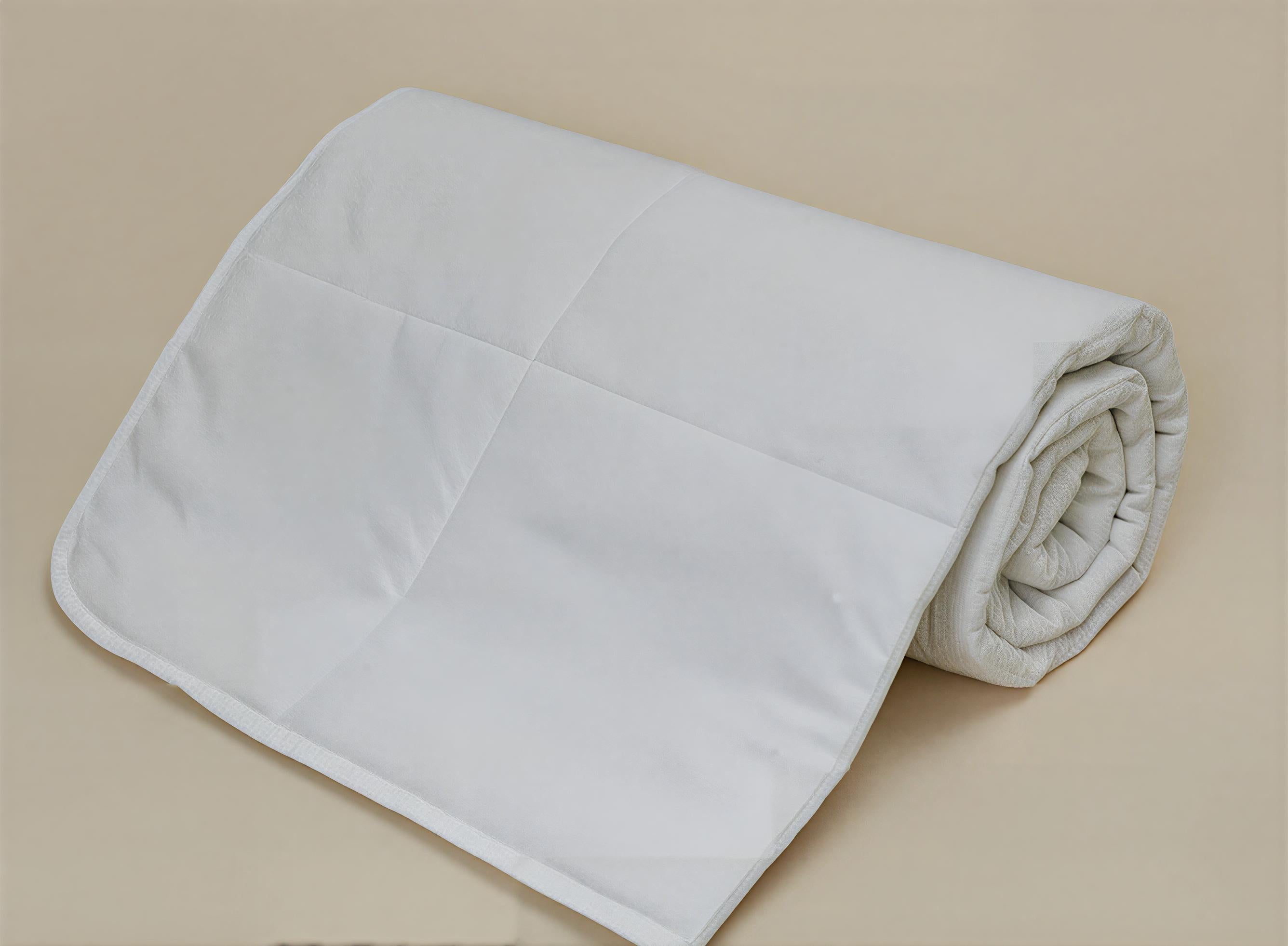 Rolled organic cotton duvet insert by Minoa Home, made with organic sheets, breathable and lightweight for all-season comfort.