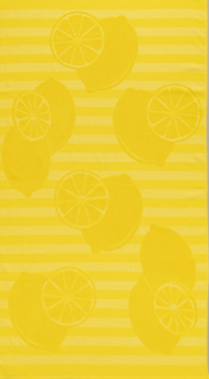 Bright yellow jacquard beach towel with lemon slice and whole fruit motifs on striped background by Minoa Home.