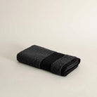 Folded dark gray towel on a beige background