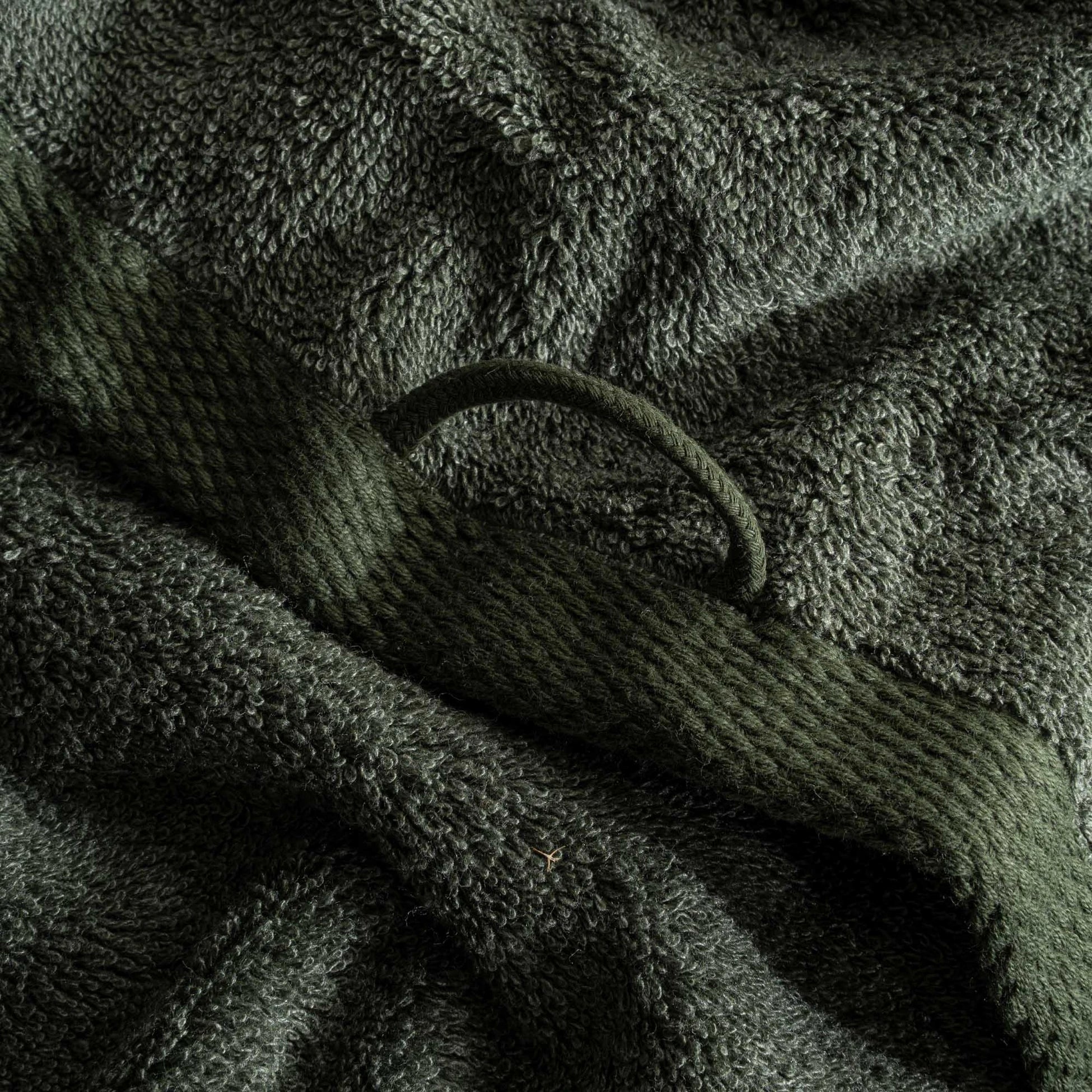 Close-up of the Naia & Cotton luxury Hand Towel in Mossy Muse, highlighting its soft texture, rich colour, and luxurious fabric, with a round loop for hanging