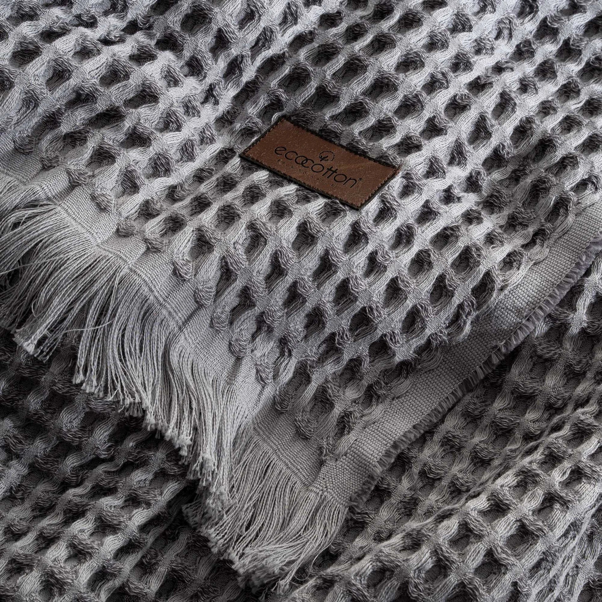 Close-up of Ecocotton tag on Organic Aegean Seren Waffle Large Throw 400g in Silver Suede, eco-friendly premium organic cotton sheets.